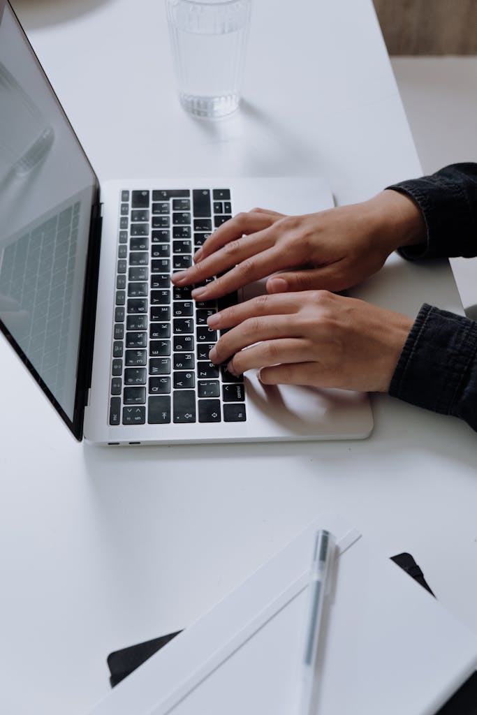 Person Using Macbook Pro on White Table